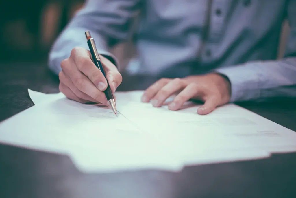 Mains d'un homme remplissant des papiers pour les changements dans les permis de travail
